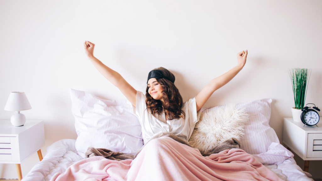 a person is laying on a bed with their arms up in the air