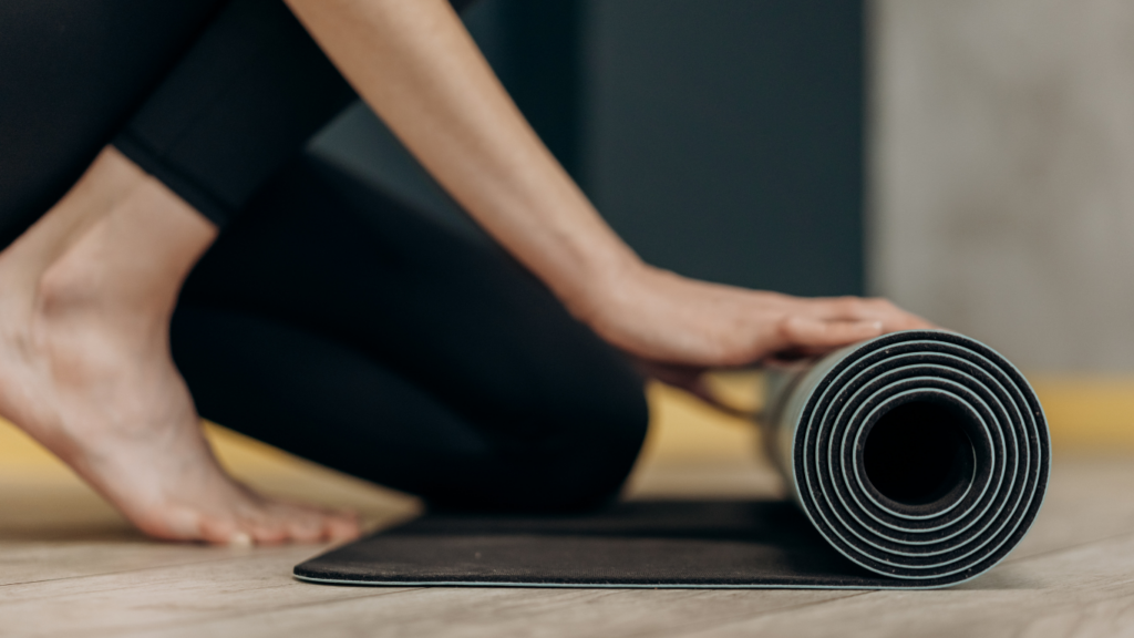 a person is putting a yoga mat on the floor