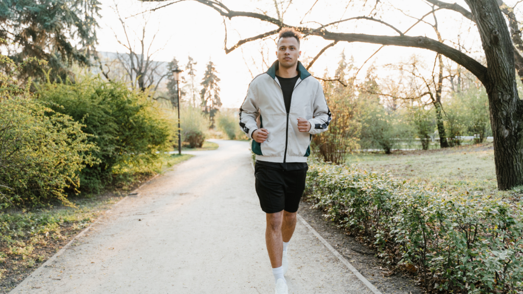 a person is jogging on a path in a park