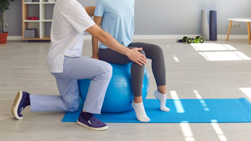 A physiotherapist working with a patient on an exercise ball