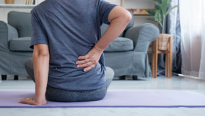 a person sitting on a yoga mat in front of a couch