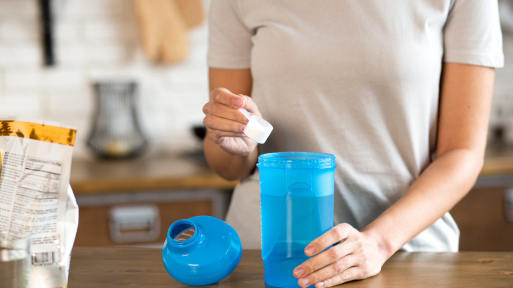 a person is pouring water into a blue bottle