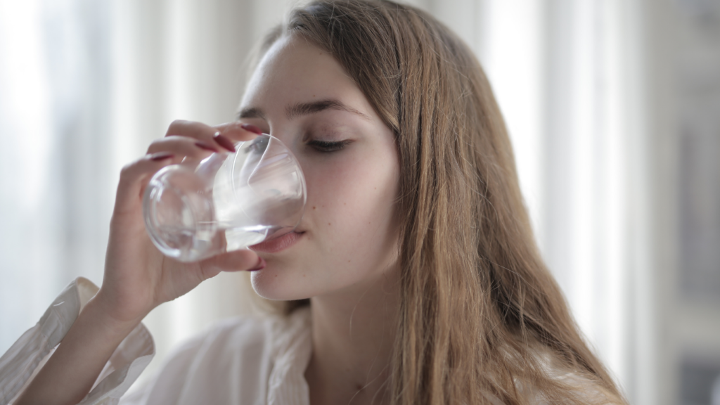 a person drinking water from a glass