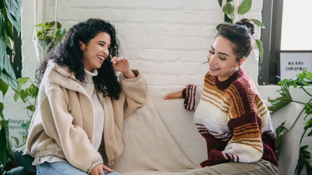 two people sitting on a couch talking to each other