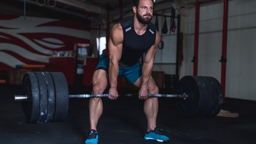 a person is squatting with a barbell in a gym