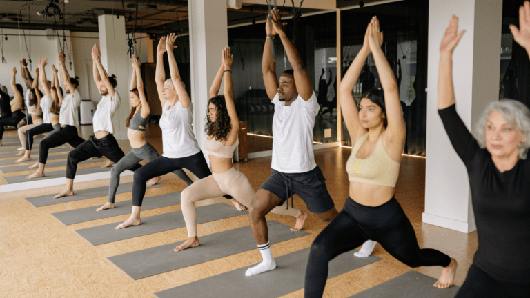 a group of people doing yoga in a gym