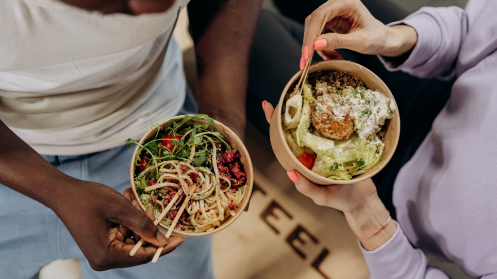 a person holding a plate with a salad on it