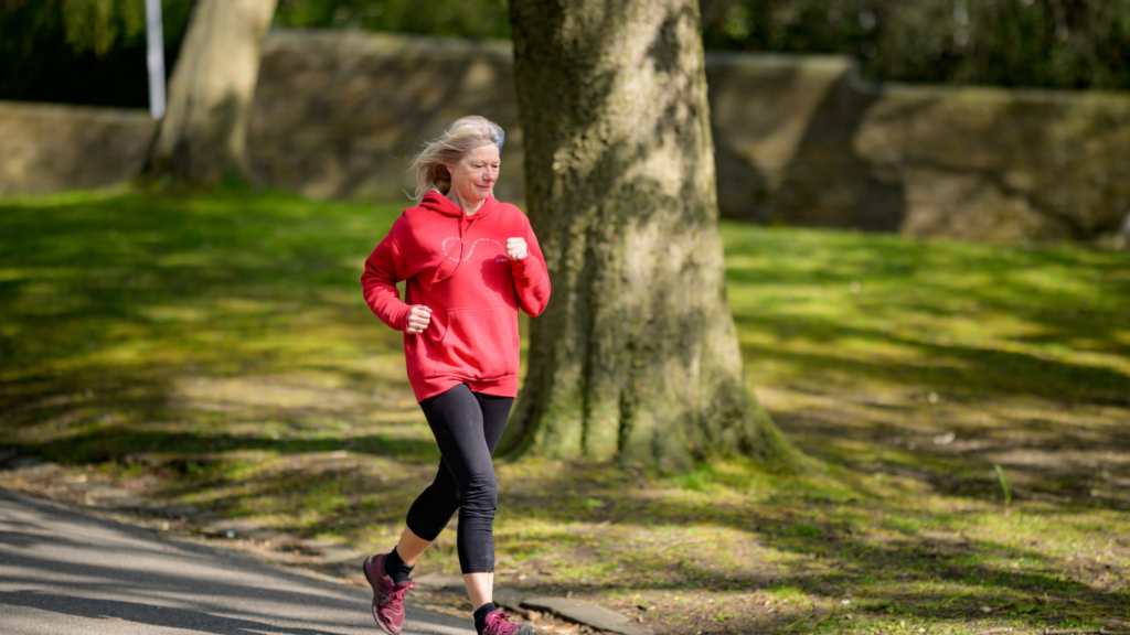 a person is jogging on a path in a park