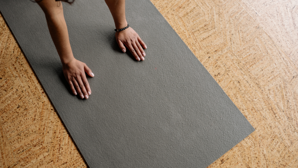 a person is putting a yoga mat on the floor