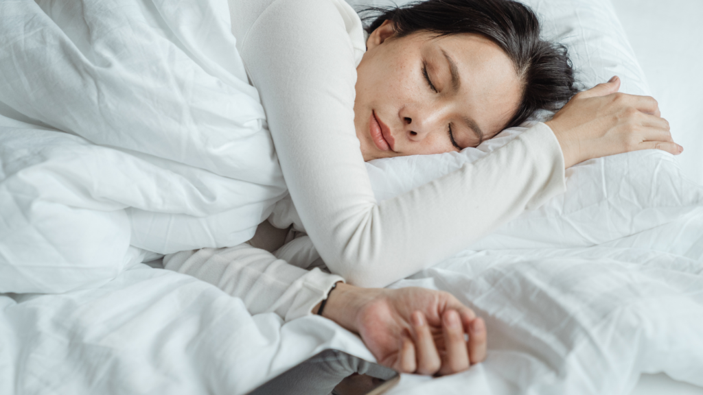 a person is sleeping in a bed with a blanket