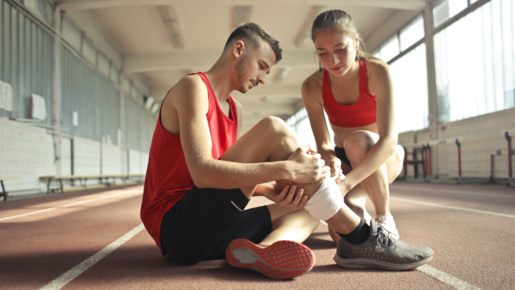 a person sitting on the floor with their knee in pain