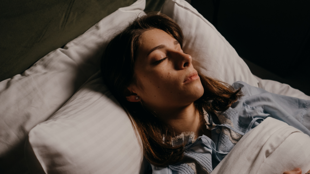 a person sleeping in bed with their eyes closed