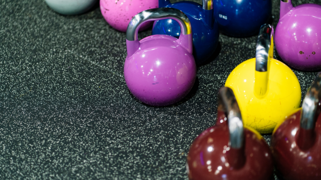 a row of colorful kettlebells in a gym